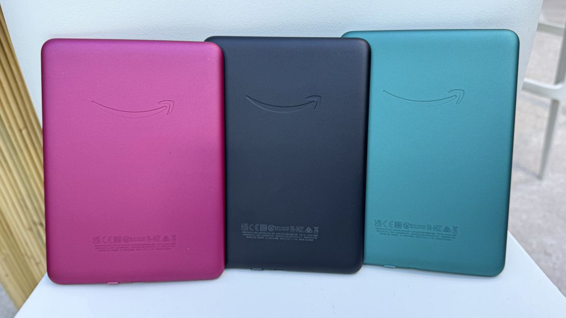 (L to R) The Raspberry (reddish purple), black and Jade (green) Kindle Paperwhite (2024) sit upright